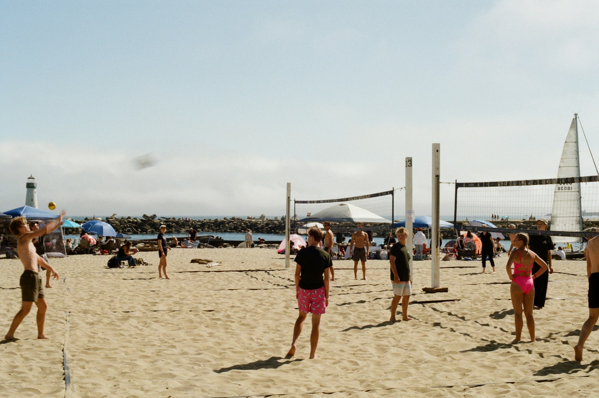 People play beach volleyball on a sunny day.